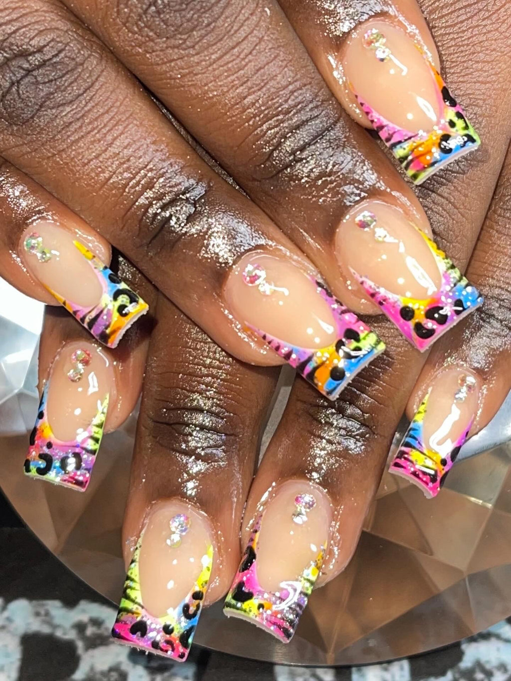 Nails with colorful designs on a reflective surface