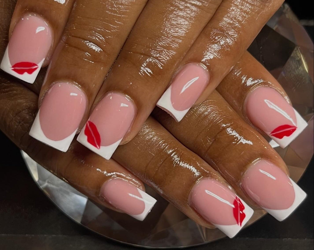 Close-up of hands with pink nail polish and red lip prints on a dark background