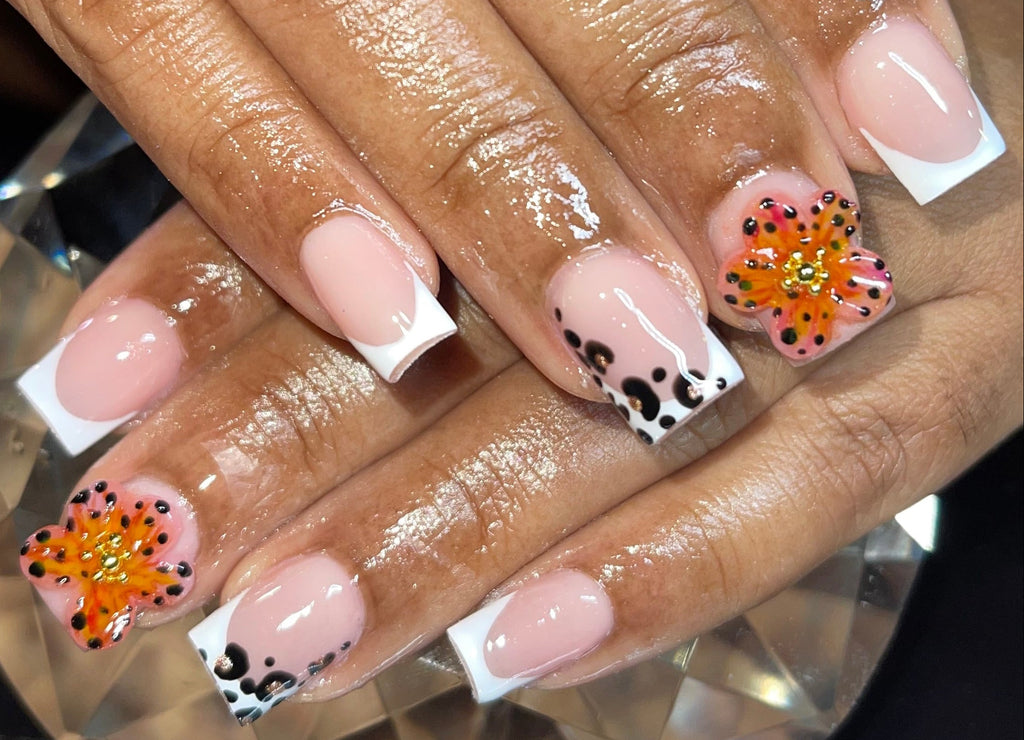 Nails with floral design and white accents on a hand