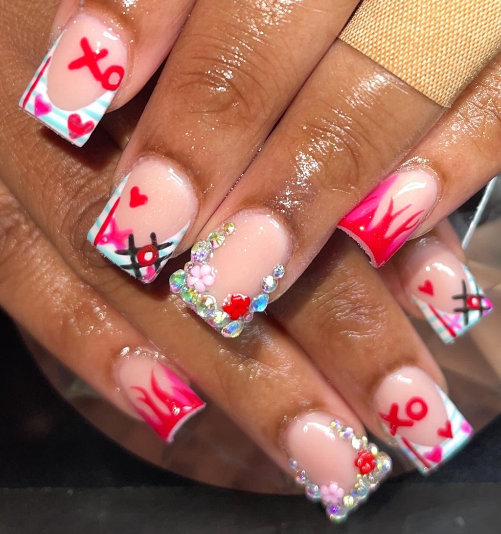 Nails with colorful designs featuring hearts and flowers on a dark background