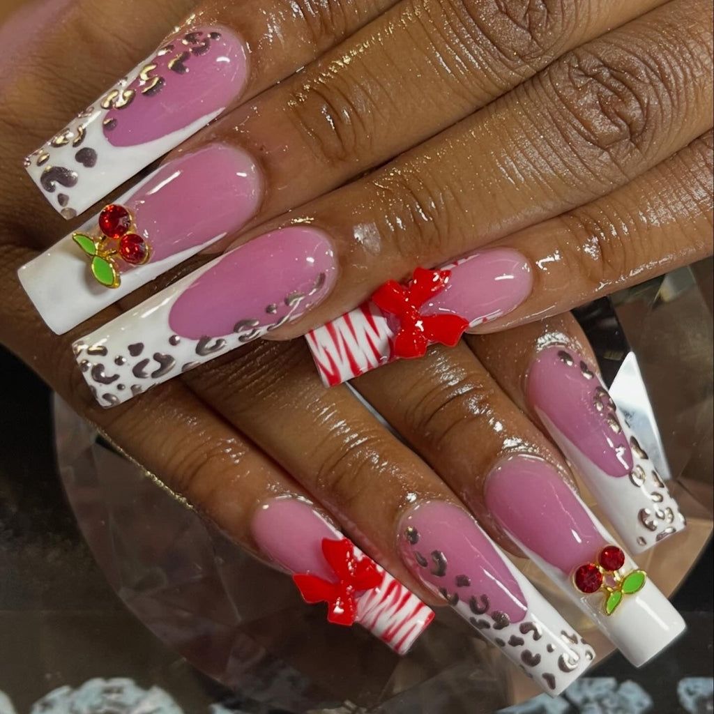 Decorative nails with pink, white, and red designs on a hand.