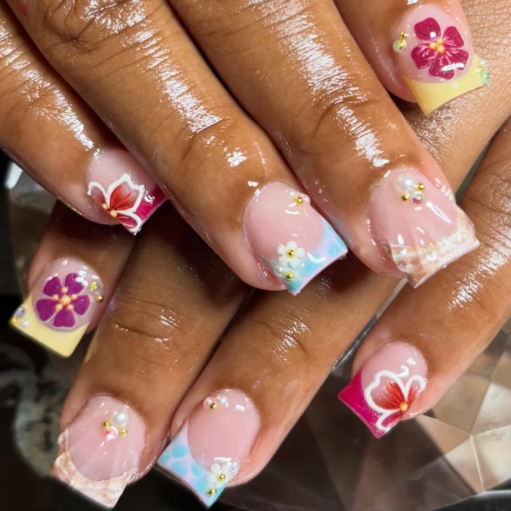 Close-up of hands with decorative nail art featuring flowers and polka dots.